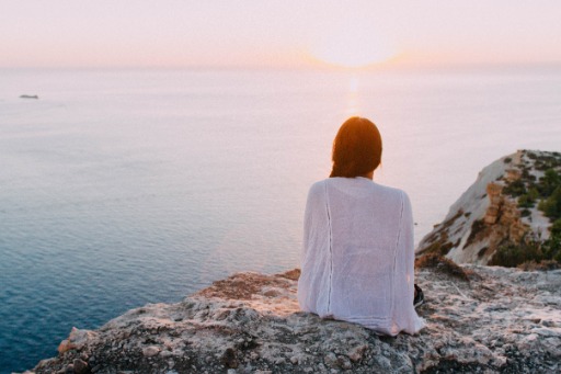 Woman sitting on a grey rock