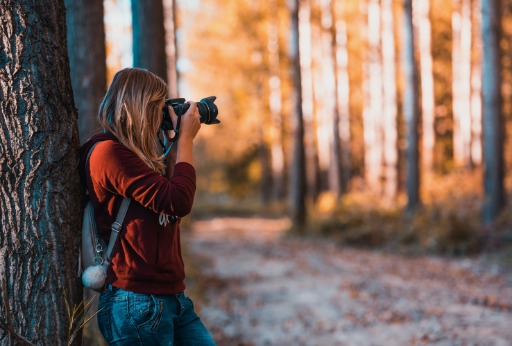 girl in the woods taking photos